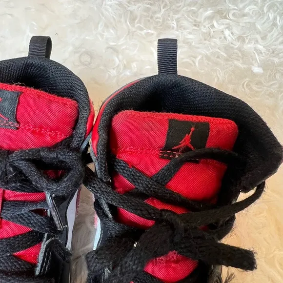 KIDS BLACK AND RED RETRO JORDAN 1  MID SIZE 10C. USED IN GOOD CONDITION.