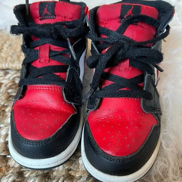 KIDS BLACK AND RED RETRO JORDAN 1  MID SIZE 10C. USED IN GOOD CONDITION.