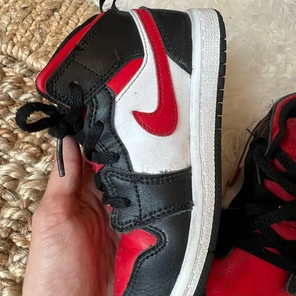 KIDS BLACK AND RED RETRO JORDAN 1  MID SIZE 10C. USED IN GOOD CONDITION.