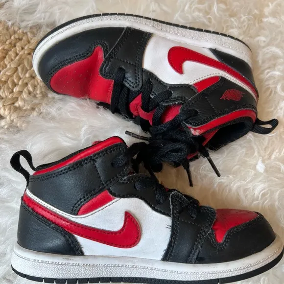 KIDS BLACK AND RED RETRO JORDAN 1  MID SIZE 10C. USED IN GOOD CONDITION.
